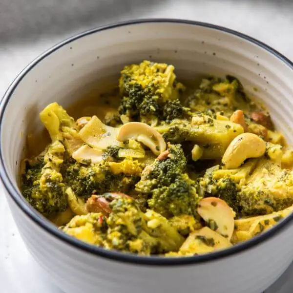 Close-up shot of Thai Green Curry, focusing on the creamy texture, vibrant vegetables, and fresh herbs.